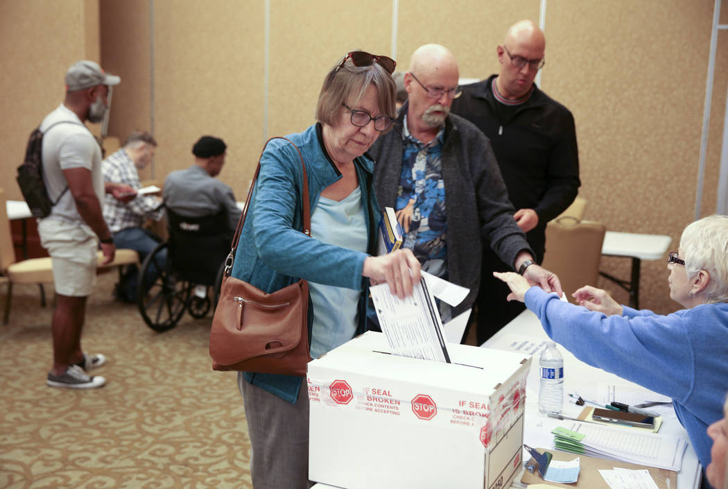Leslie Doughman, 64, de Henderson, deja caer su boleta en la urna durante la votación anticipa ...