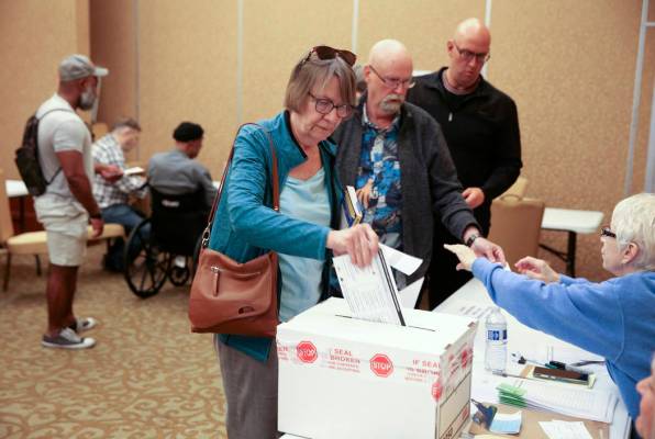 Leslie Doughman, 64, de Henderson, deja caer su boleta en la urna durante la votación anticipa ...