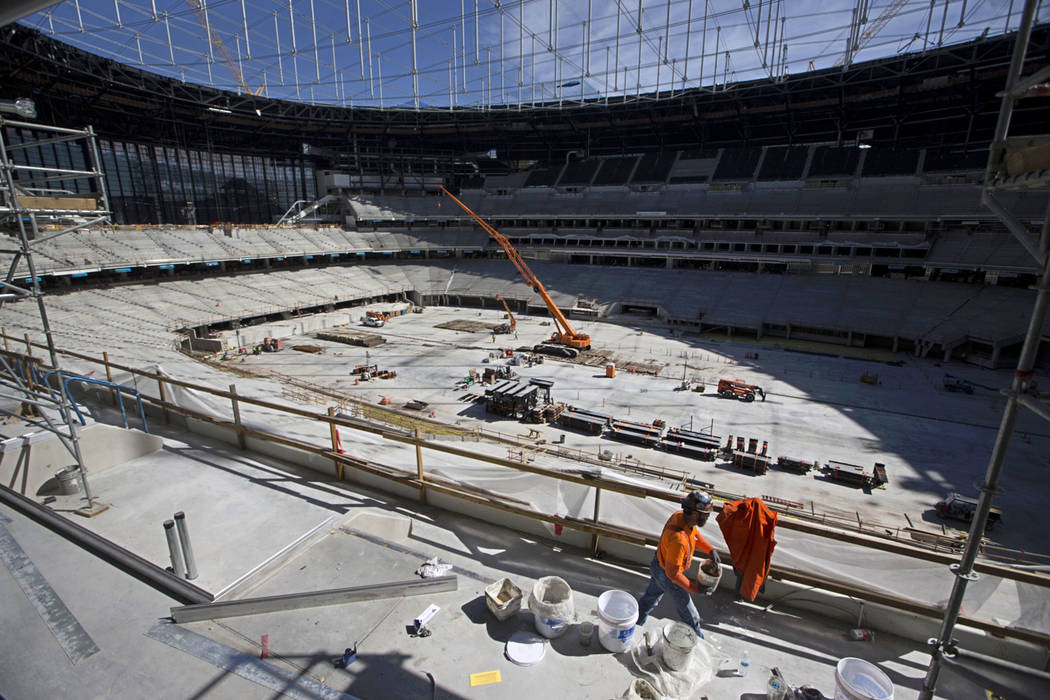 Equipos de construcción en el nivel del campo del Raiders Allegiant Stadium en Las Vegas marte ...