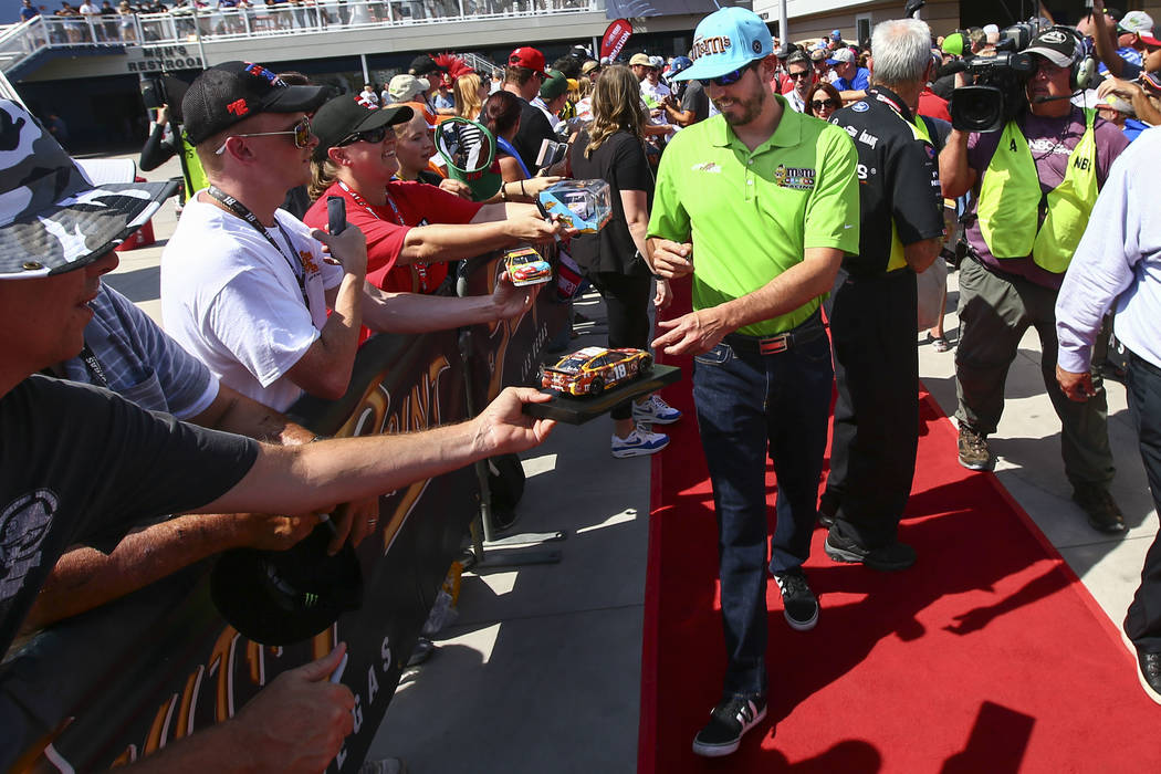 Kyle Busch firma autógrafos a los aficionados antes de una carrera de autos de la Copa NASCAR ...