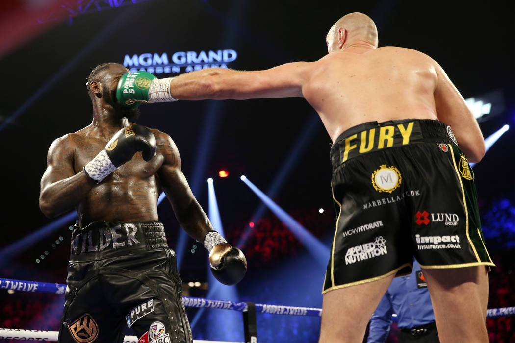 Tyson Fury, derecha, conecta un golpe contra Deontay Wilder en la segunda ronda del combate del ...