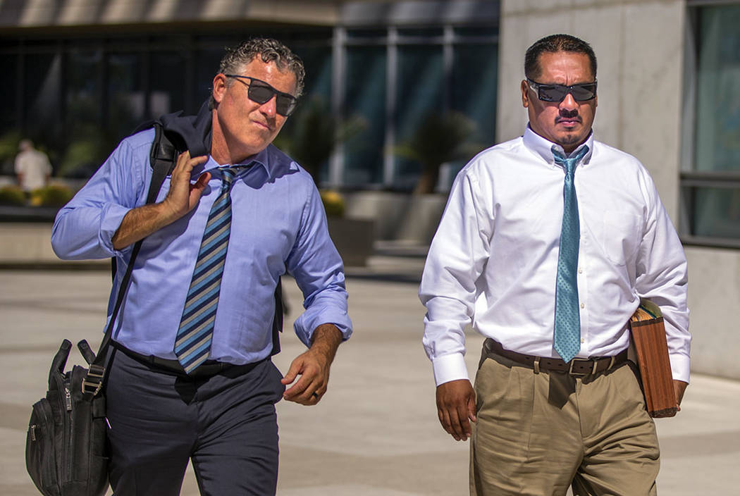 El abogado Mark Fleming, izquierda, camina con el acusado Albert López el 12 de agosto de 2019 ...