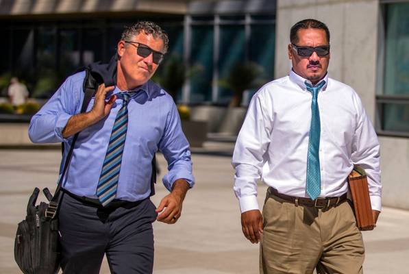 El abogado Mark Fleming, izquierda, camina con el acusado Albert López el 12 de agosto de 2019 ...