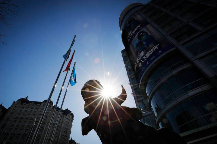 Una estatua de un toro, un icono de la inversión, se encuentra fuera de un edificio de oficina ...