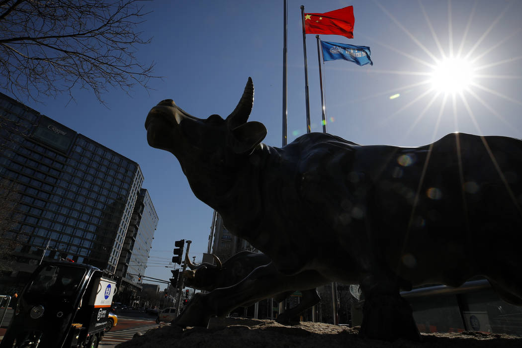 Una estatua de un toro, un icono de la inversión, se encuentra fuera de un edificio de oficina ...