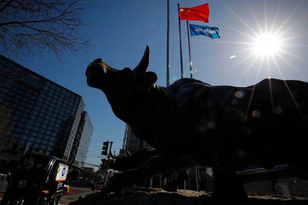 Una estatua de un toro, un icono de la inversión, se encuentra fuera de un edificio de oficina ...