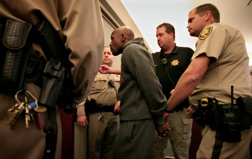 Los oficiales escoltan al boxeador Floyd Mayweather Jr. fuera de la sala del Centro Regional de ...