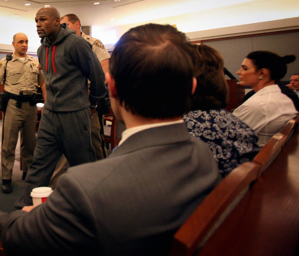 Los oficiales escoltan al boxeador Floyd Mayweather Jr. fuera de la sala del Centro Regional de ...