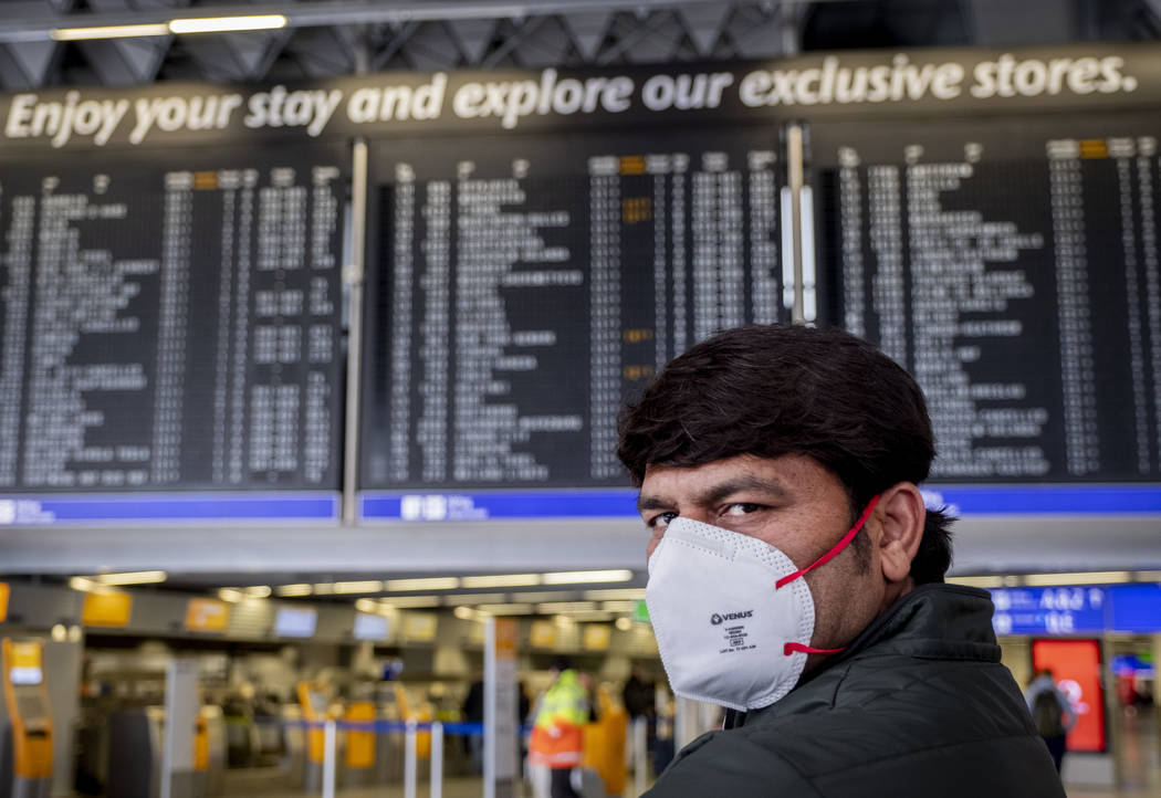 Un pasajero de la India espera su vuelo en una terminal del aeropuerto de Frankfurt, Alemania e ...