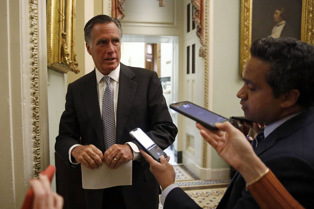 El senador Mitt Romney, republicano por Utah, habla con miembros de los medios al salir de una ...