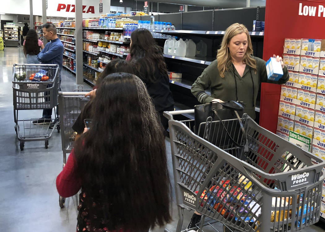 Meg Nelson, derecha, de Las Vegas, compra en WinCo Foods el lunes, 16 de marzo de 2020, en Las ...