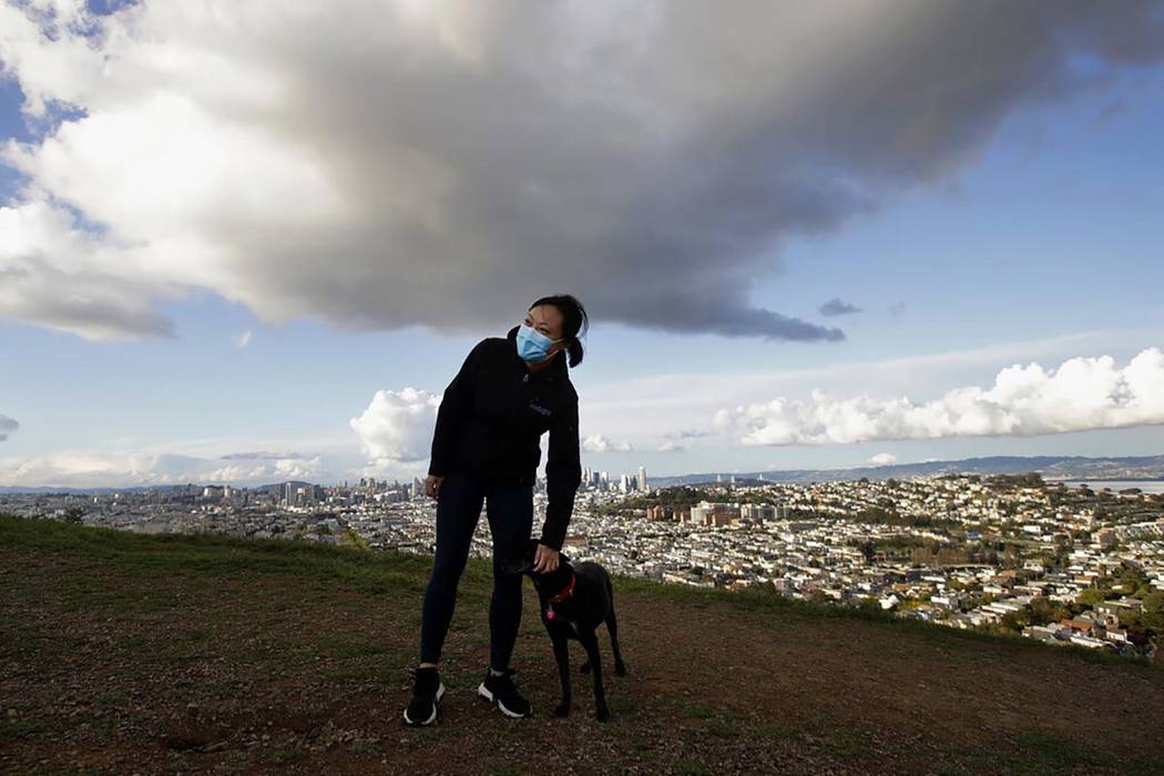 Lisa Wang lleva una máscara mientras pasea a su perro Rooney en Bernal Heights Hill en San Fra ...