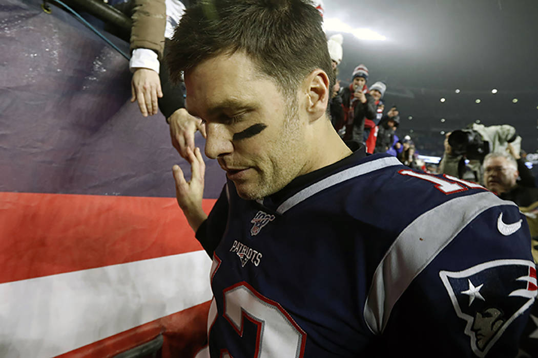 El mariscal de campo de los New England Patriots, Tom Brady, da la mano a un aficionado cuando ...