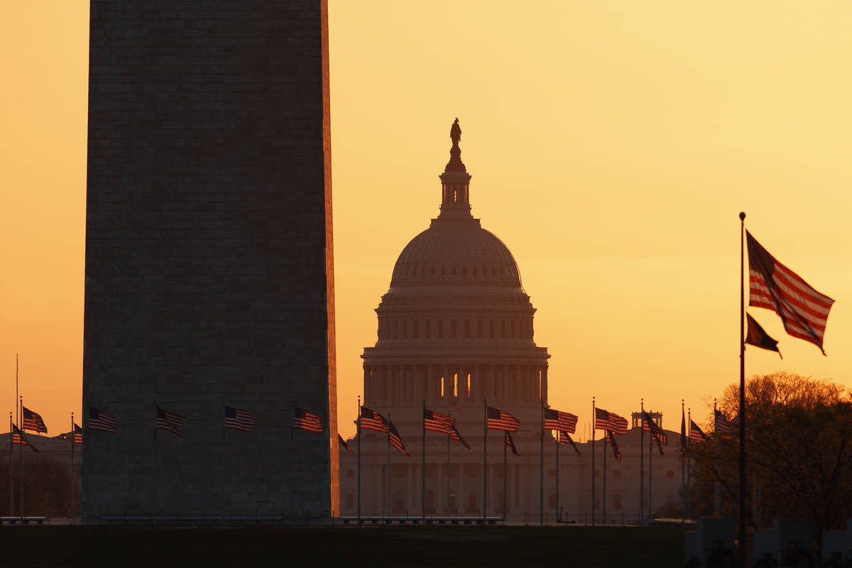 El Monumento a Washington y el Capitolio de Estados Unidos se ven en Washington, al amanecer de ...