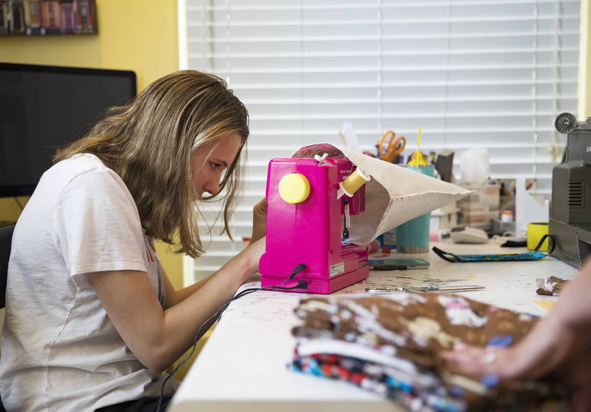 Grace Gustafson, de 13 años, elabora cubrebocas en su casa de Las Vegas el domingo, 22 de marz ...