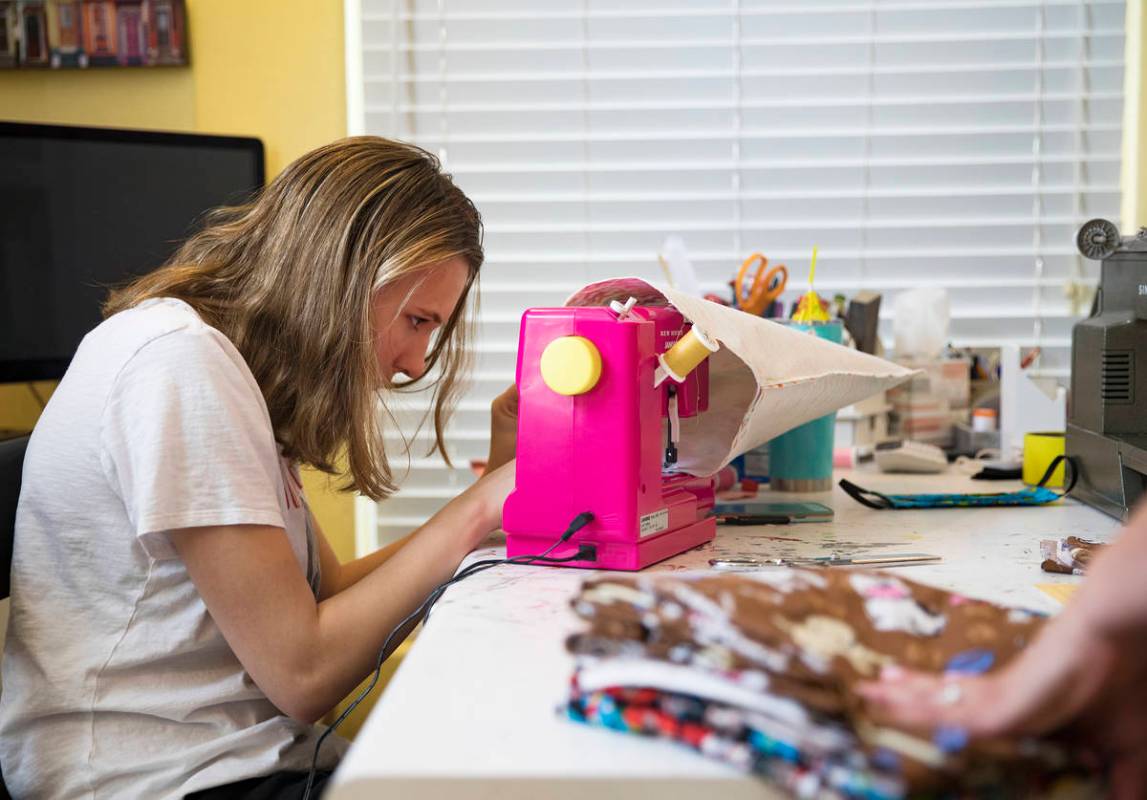 Grace Gustafson, de 13 años, elabora cubrebocas en su casa de Las Vegas el domingo, 22 de marz ...