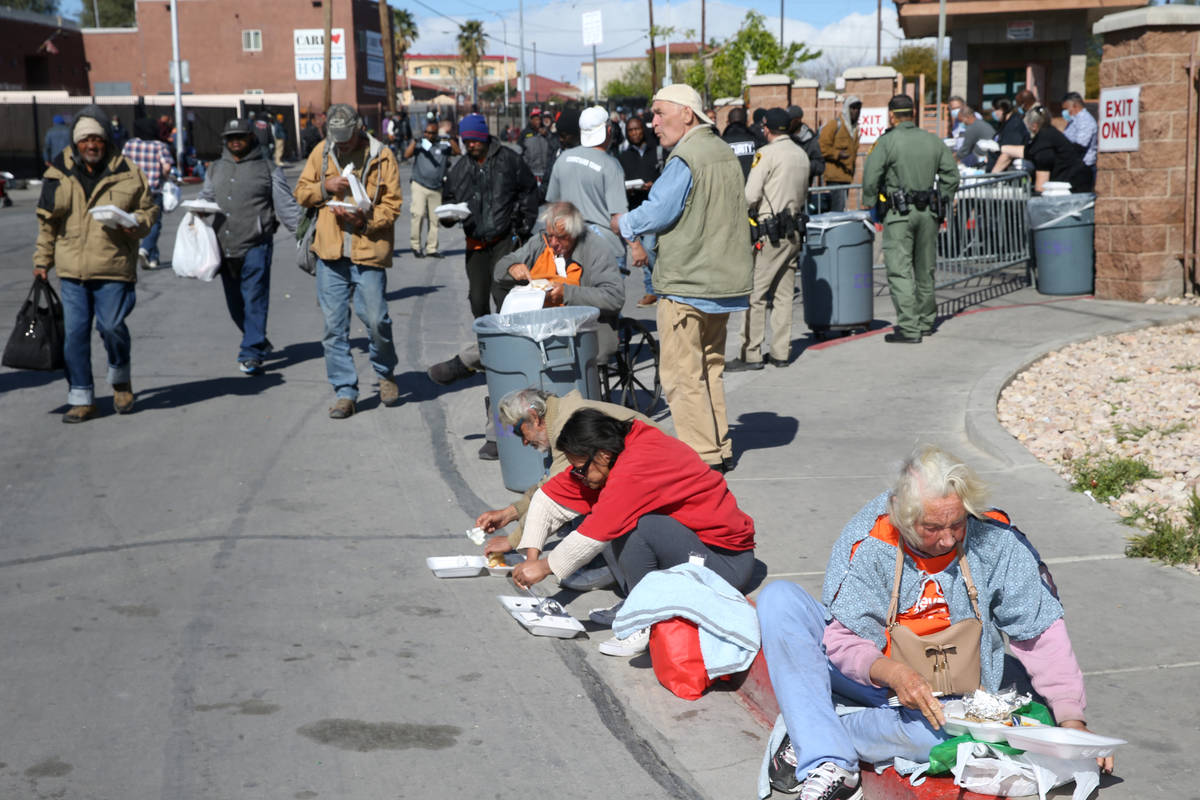 Gente come almuerzos para llevar de Catholic Charities en Foremaster Lane en Las Vegas el jueve ...