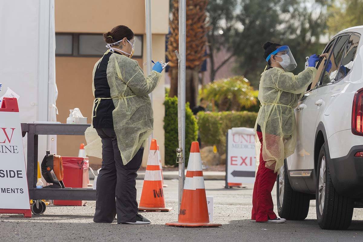 Profesionales médicos de UNLV Medicine realizan una prueba en la acera a un paciente que exper ...