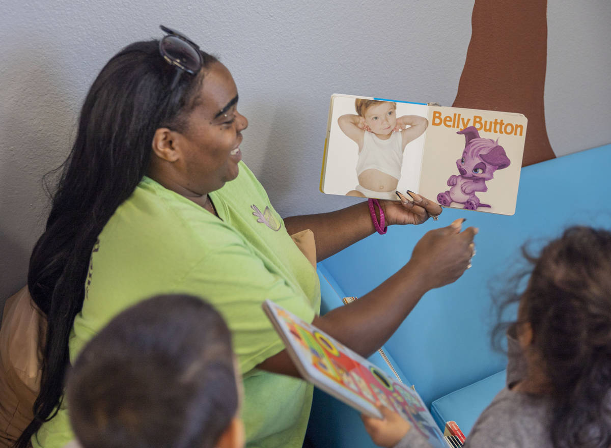 La maestra de Discovery Gardens Childcare, Demetria Robinson, lee un libro a su clase de niños ...
