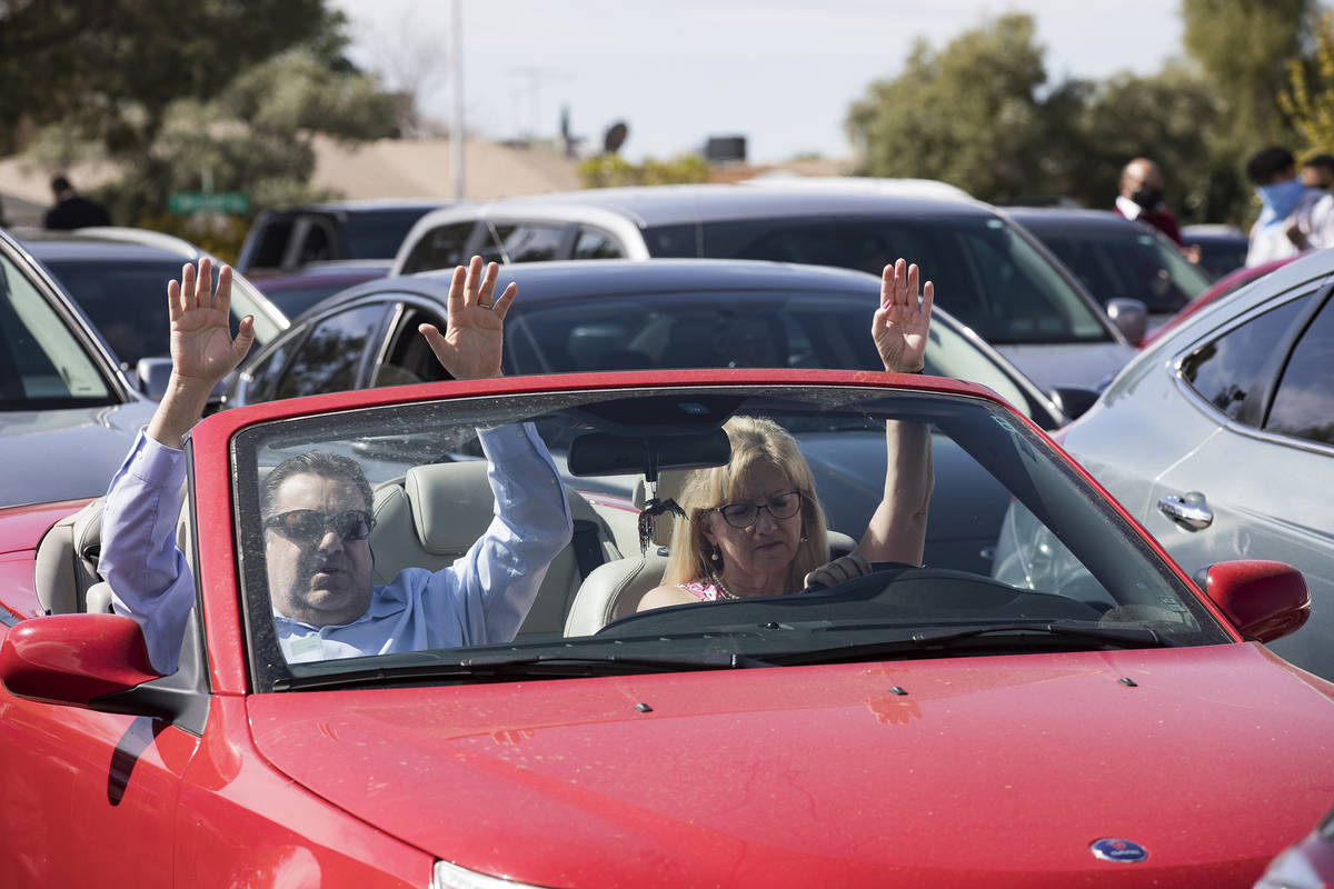 David Howard y su esposa, Tina Howard, alzan las manos desde su auto en una misa de Pascua en e ...