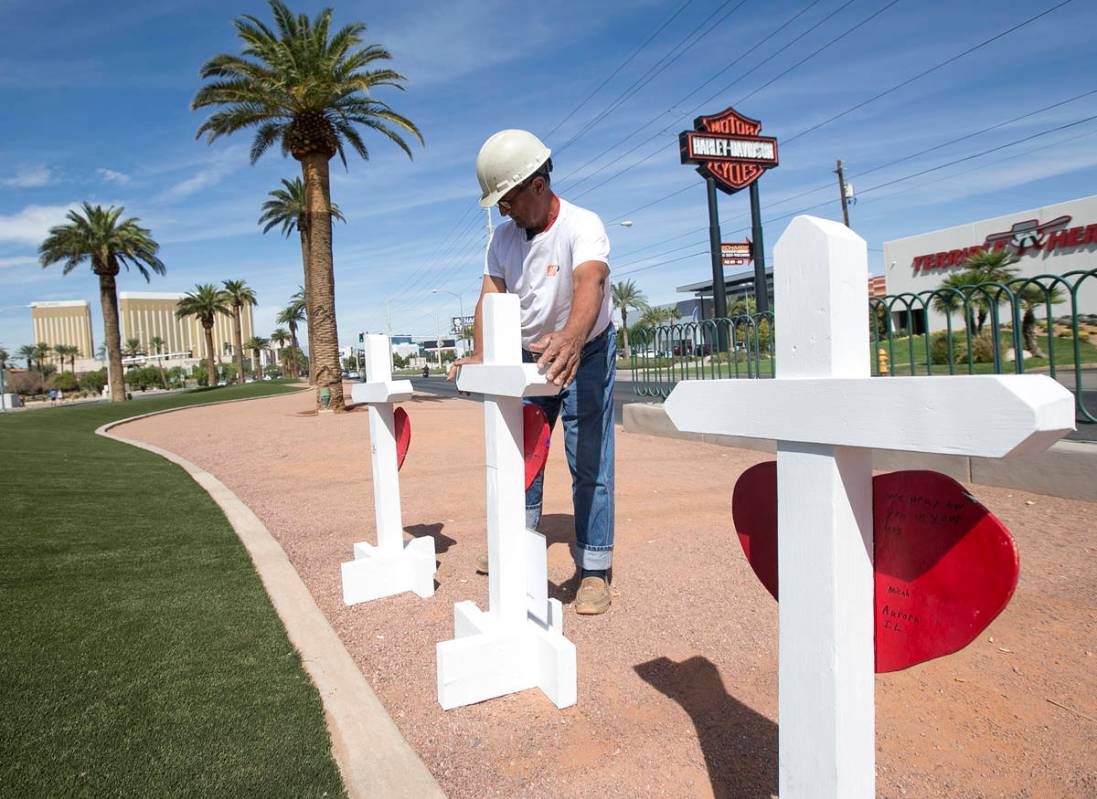 Greg Zanis, de Aurora, Ill., lleva una de las 58 cruces que colocó cerca del letrero "Welcome ...