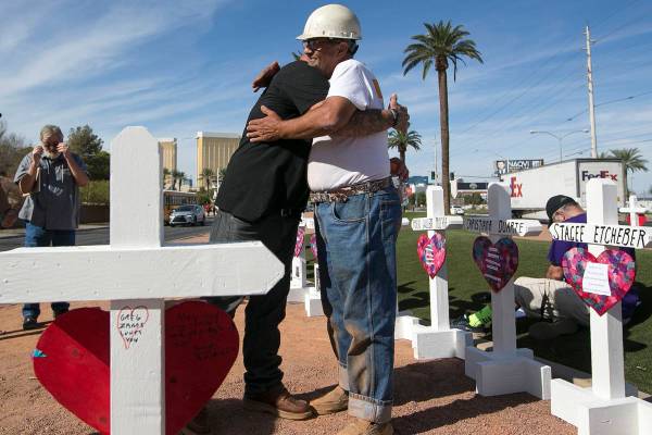 El fabricante de cruces Greg Zanis, derecha, recibe un abrazo de Mike Warino, hermano de la ví ...