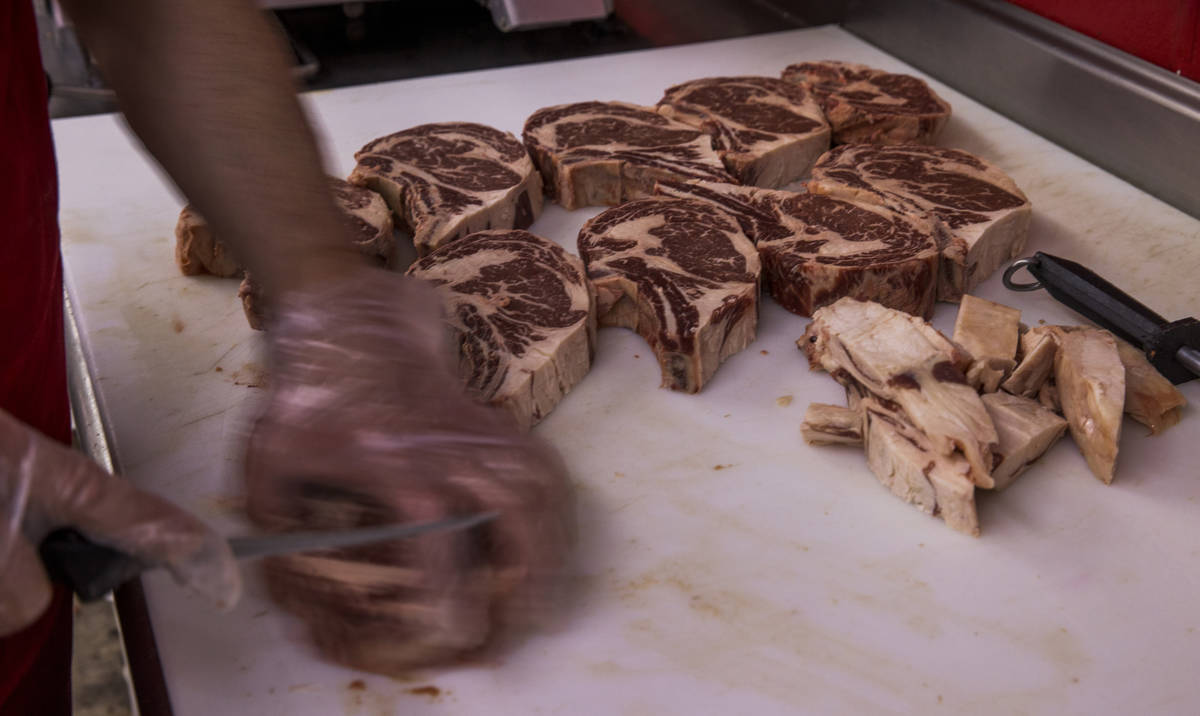El dueño Óscar Nuno Sr., corta ribeye de carne en el Mercado de Carne Los Primos el domingo, ...