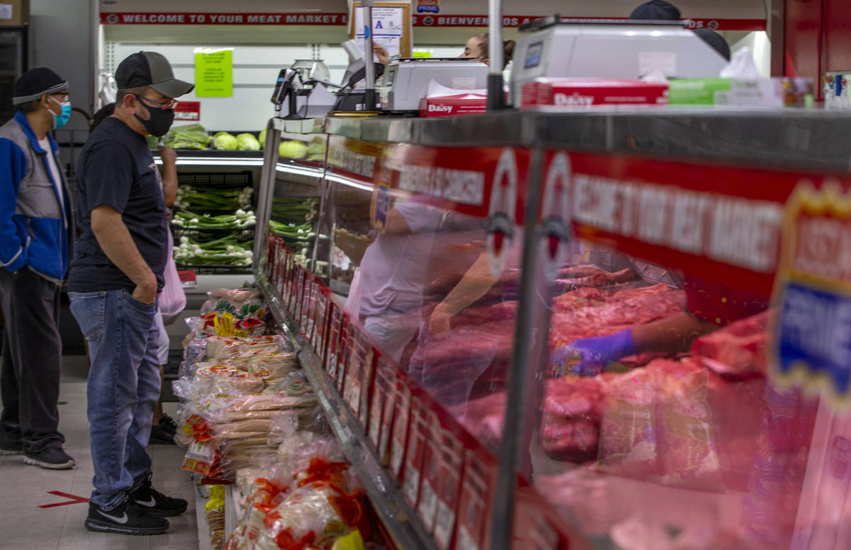Los clientes miran las cajas de carne para sus compras en el Mercado de Carne Los Primos el dom ...