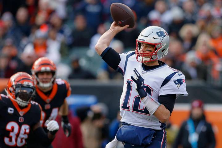 El mariscal de campo de los New England Patriots, Tom Brady (12), pasa el balón en la primera ...