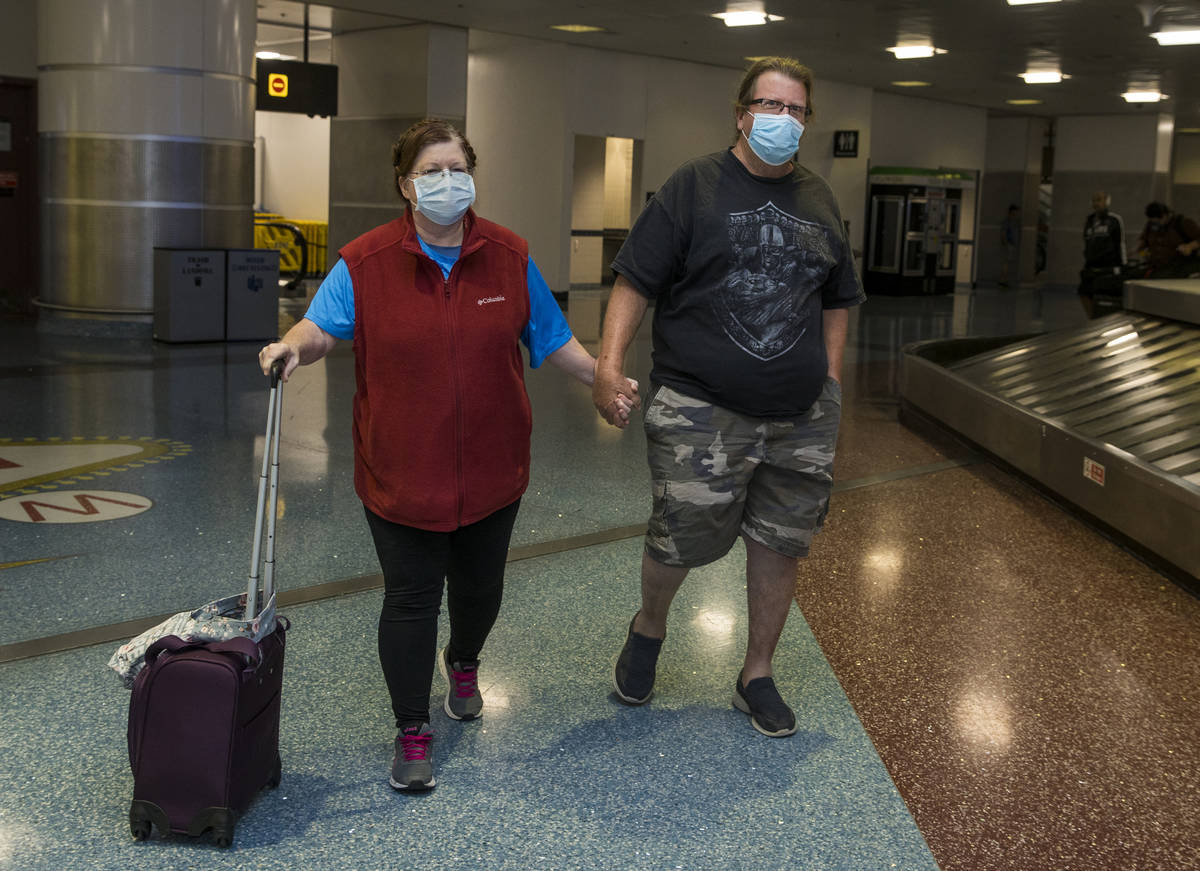 Susan Yowell y su marido Jack se toman de la mano al salir de la Terminal 1 de reclamo de equip ...