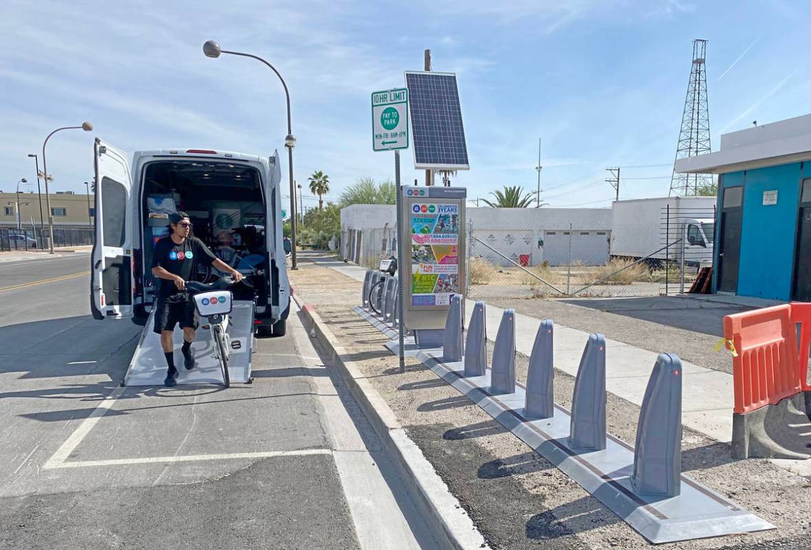 Un trabajador de la Comisión Regional de Transporte recarga una estación de Bike Share de la ...