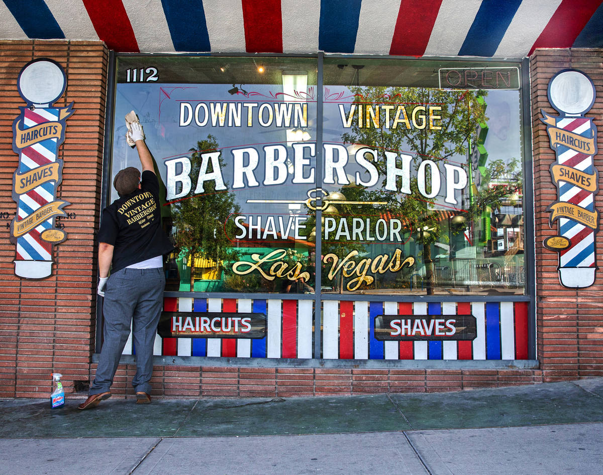 Jorge Reyes, propietario de Downtown Vintage Barbershop, limpia su tienda en preparación para ...
