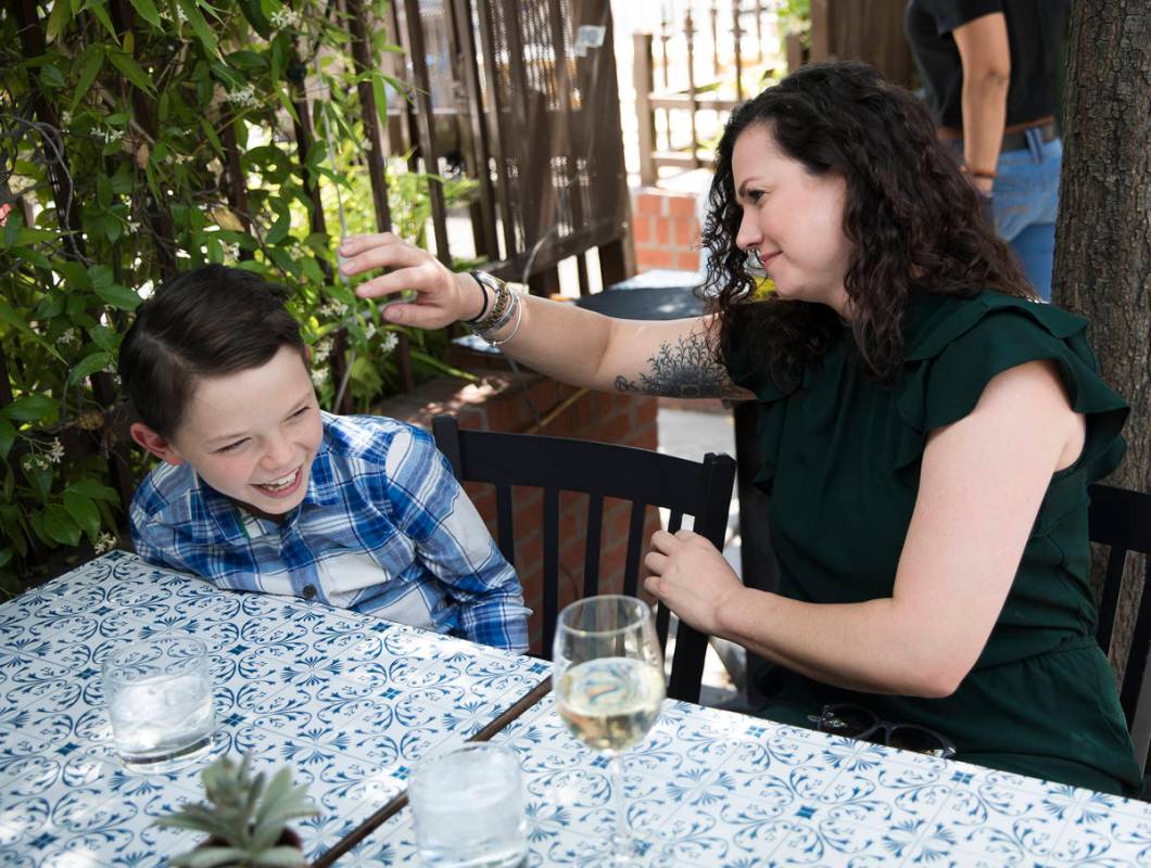 Nicole Silverman arregla el cabello de su hijo Berkeley Brady, de ocho años, mientras almuerza ...