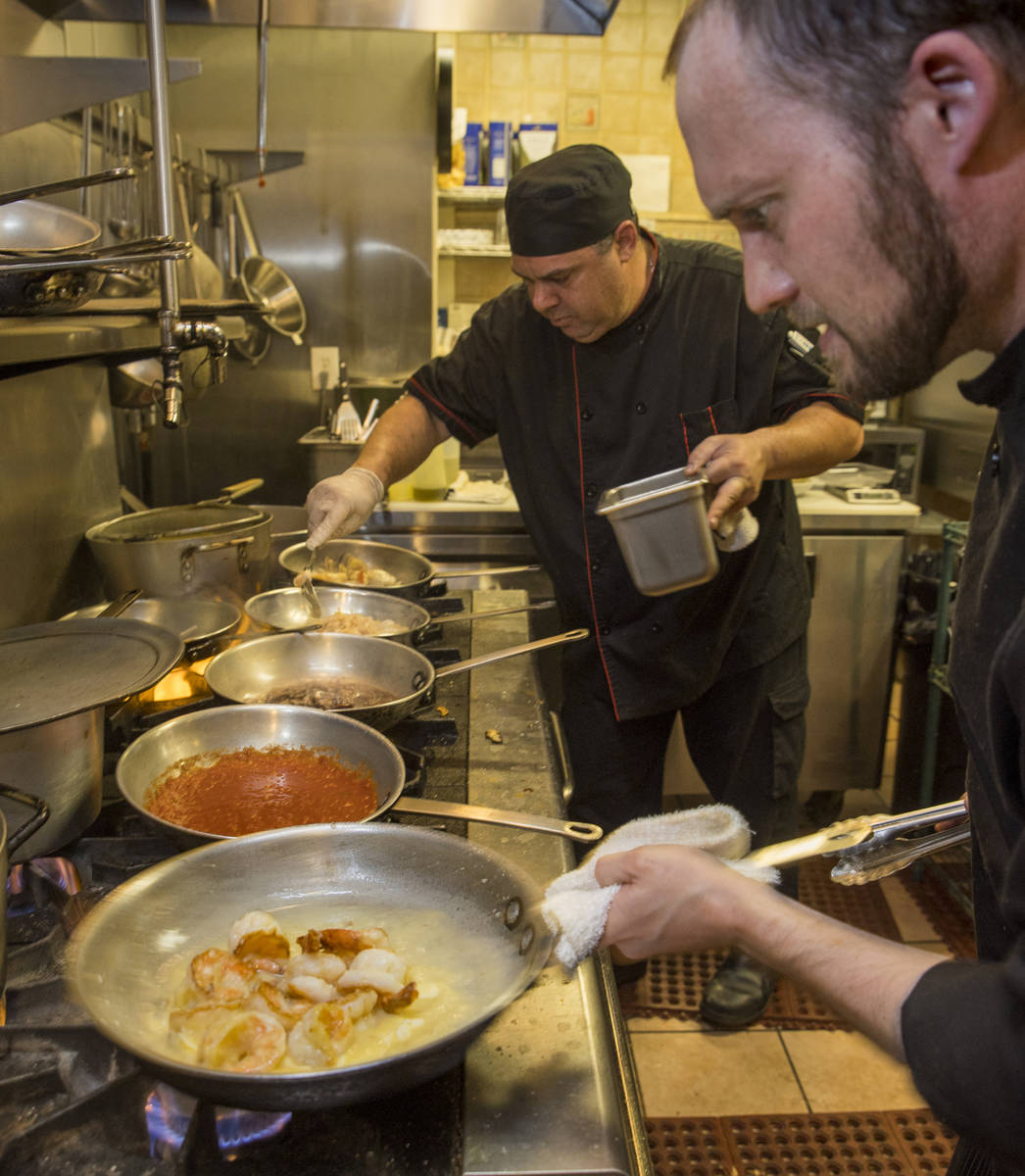 El chef Michael Prout, derecha, y el propietario/jefe de cocina Dan Thompson, preparan más pla ...
