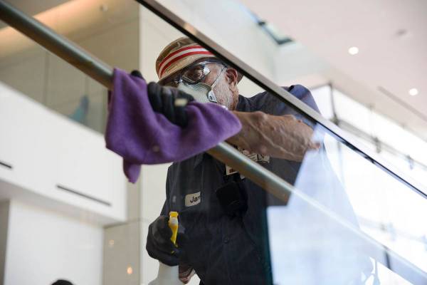 El Custodio Jarrell Siler desinfecta los pasamanos del Hospitality Hall de la UNLV en Las Vegas ...