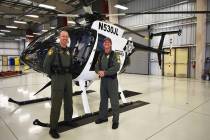 El oficial Ryan Petersen (izquierda) y el sargento Spencer Basner posan frente a un helicópter ...