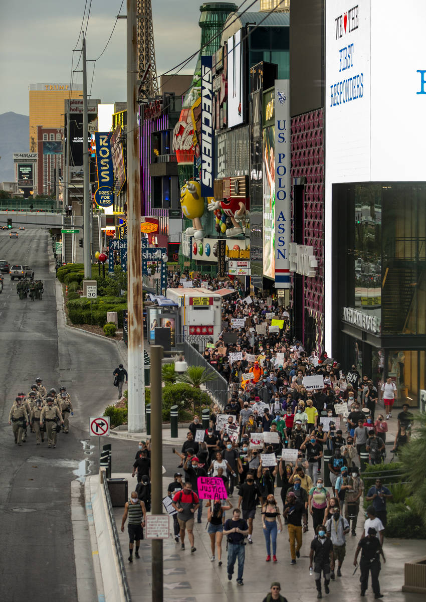 Oficiales de policía de Las Vegas y manifestantes de Black Lives Matter caminan por el Strip d ...