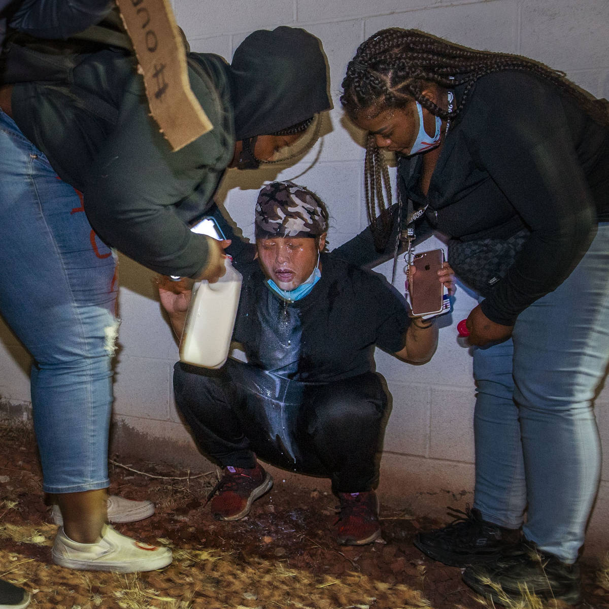 Manifestantes acuden en ayuda de otro que fue gaseado por la policía de Las Vegas durante una ...