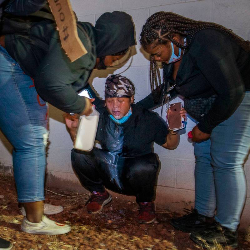 Manifestantes acuden en ayuda de otro que fue gaseado por la policía de Las Vegas durante una ...