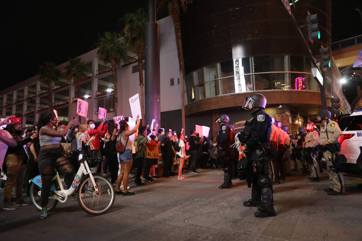 Manifestantes levantan los puños ante los policías de Las Vegas durante una protesta de "Blac ...