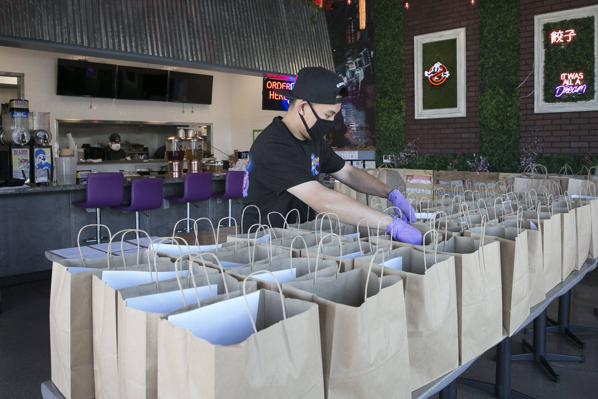 Ronald Duong, empleado del restaurante Graffiti Bao, prepara bolsas de comida para ser entregad ...