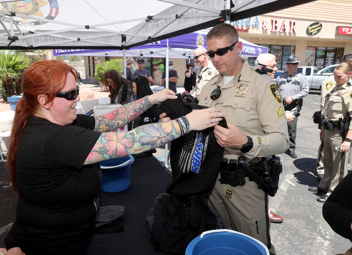 La policía de Las Vegas, Christina Pettit, ayuda a Matt Dannenberger a comprar una camiseta du ...