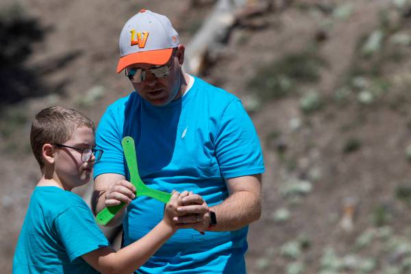 Jeff Whitehead enseña a su hijo, Garrett Whitehead, de 8 años, cómo lanzar un bumerán en el ...