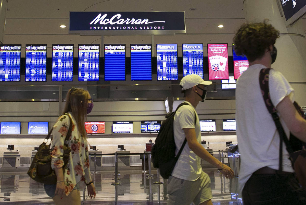 Pasajeros pasan por el letrero del Aeropuerto Internacional McCarran el miércoles, 24 de junio ...