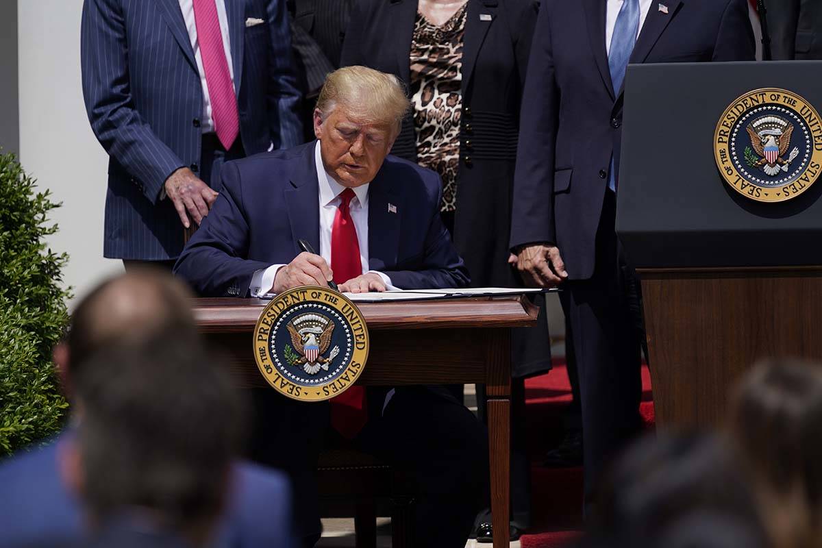 El presidente Donald Trump firma la Paycheck Protection Program Flexibility Act durante una con ...