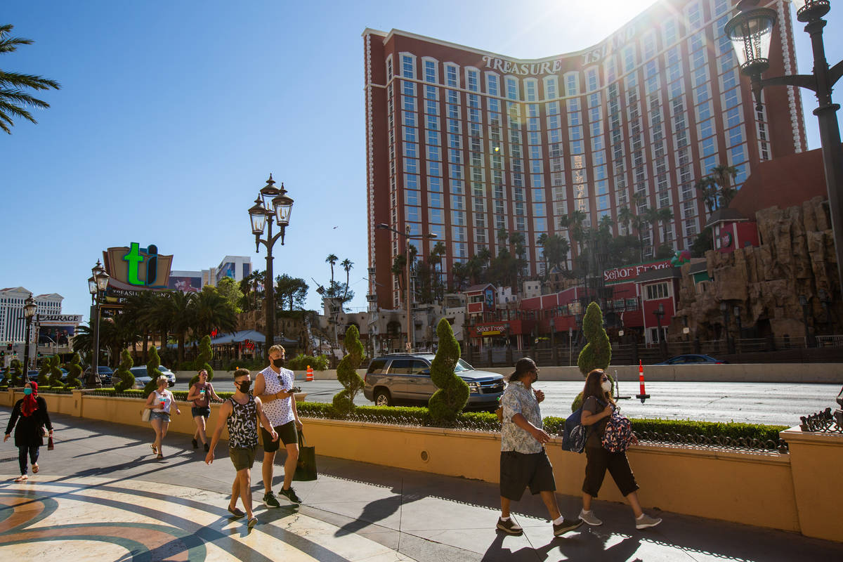 Gente camina por el Strip frente a Treasure Island en Las Vegas el viernes, 3 de julio de 2020. ...