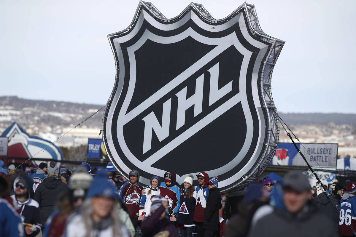 En esta foto del 15 de febrero de 2020, aficionados posan bajo el logo de la liga NHL en una ex ...