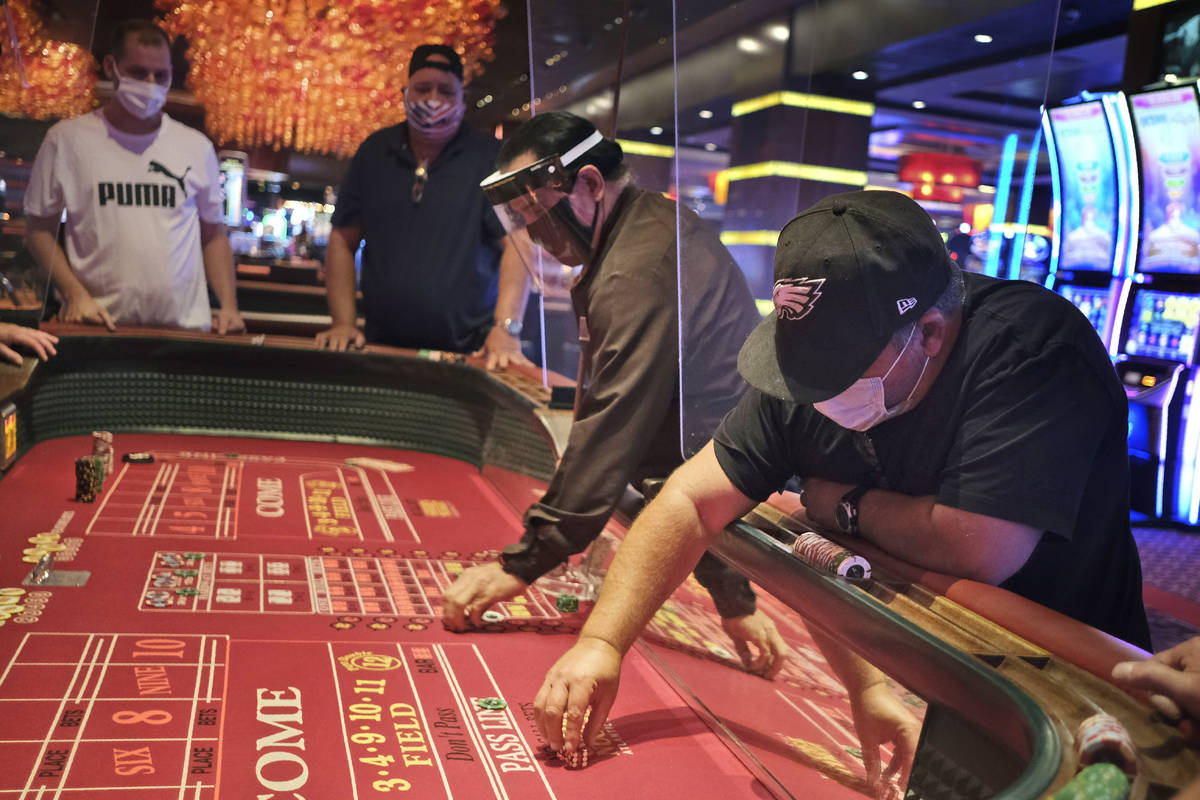 Jugadores y repartidores de dados están separados por tabiques en el Casino Golden Nugget en A ...