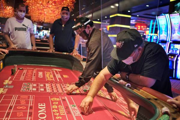 Jugadores y repartidores de dados están separados por tabiques en el Casino Golden Nugget en A ...