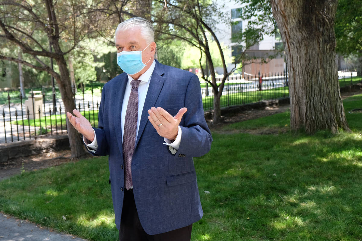 Un enmascaradogGobernador Steve Sisolak habla con los reporteros fuera del Capitolio durante la ...